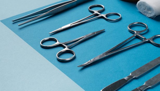 Um fundo azul com tesouras, piças e outros acessórios cirúrgicos